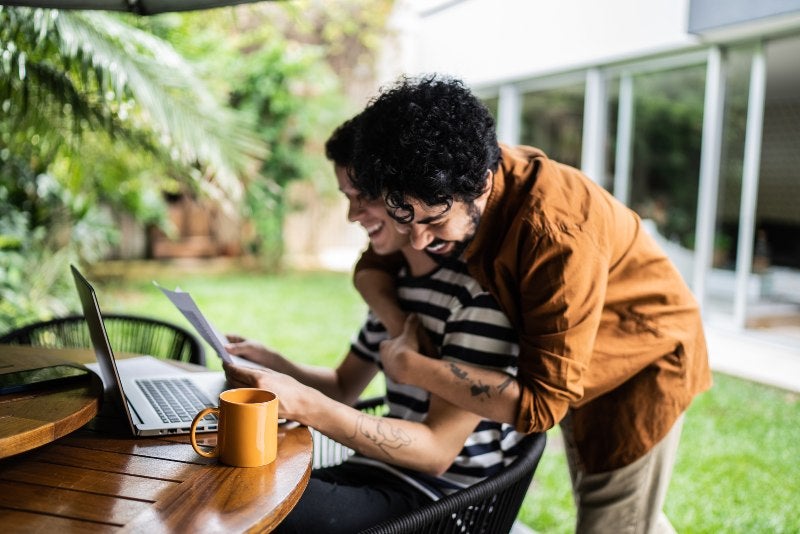 LGBTQ+ Couple Embracing Happily in the Backyard After Estate Planning in Tracy, CA