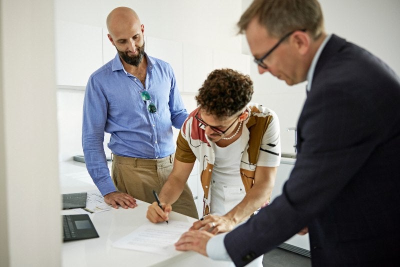 Couple Signing Legal Papers for LGBTQ+ Estate Planning in Tracy, CA