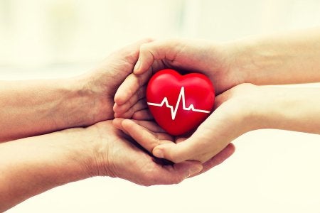 Hand holding a heart-shaped toy, symbolizing charitable giving through a living trust in Tracy, CA